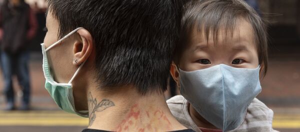 Ребенок в защитной маске на руках отца на одной из улиц в Гонконге. - Sputnik Армения