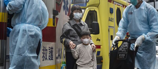 Женщина с ребенок в защитных масках рядом с автомобилем скорой помощи на одной из улиц в Гонконге. - Sputnik Армения