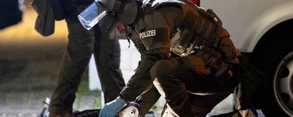 Офицер спецназа работает над роботом перед домом, который обыскивает полиция в Ханау после стрельбы в кальянной, где были убиты 8 человек (19 февраля 2020). Германия Офицер спецназа работает над роботом перед домом, который обыскивает полиция в Ханау после стрельбы в кальянной, где были убиты 8 человек (19 февраля 2020). Германия - Sputnik Армения