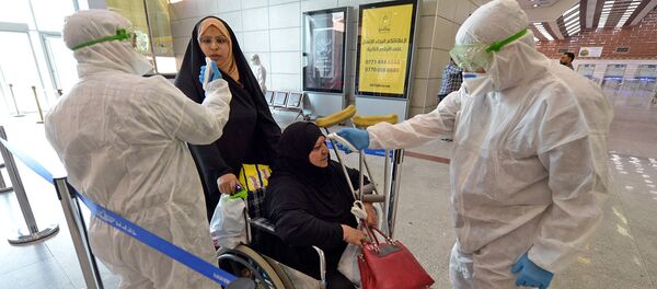 Медицинский персонал проверяет пассажиров в Международном аэропорту Наджаф после того как Иран объявил о случаях заражения коронавирусом в Исламской Республике (21 февраля 2020).  - Sputnik Армения