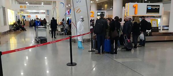 Сотрудник Минздрава в спецодежда встречает пассажиров из Ирана - Sputnik Армения