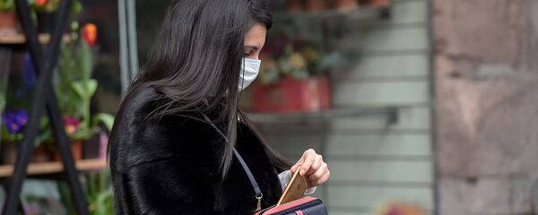 Женщина в маске у цветочного магазина в Ереване Женщина в маске у цветочного магазина в Ереване - Sputnik Արմենիա