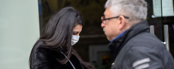 Женщина в маске у цветочного магазина в Ереване Женщина в маске у цветочного магазина в Ереване - Sputnik Արմենիա