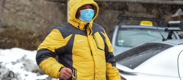 Мужчина на закрытом перекрестке, ведущим к отелю Golden Palace (1 марта 2020). Цахкадзор - Sputnik Армения