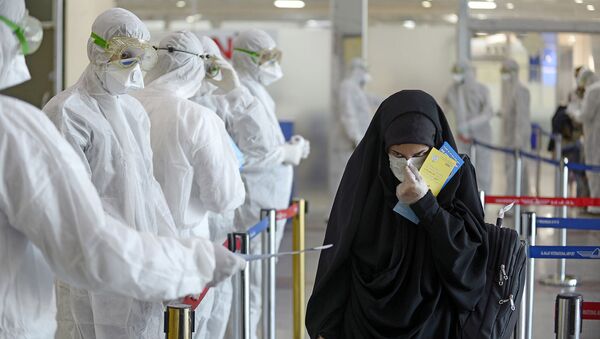 Медицинский персонал измеряет температуру пассажиров, возвращающихся из Ирана в международном аэропорту Наджаф (5 марта 2020). Ирак - Sputnik Армения