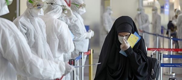 Медицинский персонал измеряет температуру пассажиров, возвращающихся из Ирана в международном аэропорту Наджаф (5 марта 2020). Ирак - Sputnik Армения