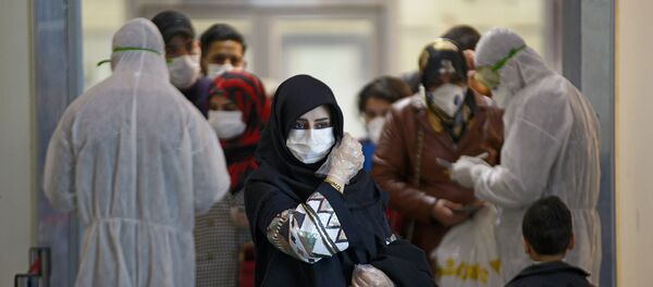 Медицинский персонал измеряет температуру пассажиров, возвращающихся из Ирана в международном аэропорту Наджаф (5 марта 2020). Ирак - Sputnik Армения