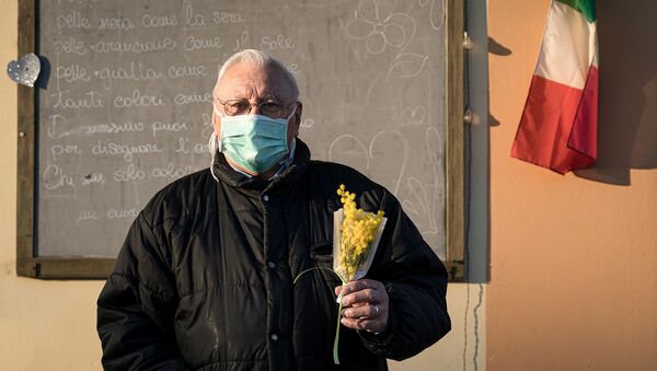 Жизнь в красной зоне: человек в защитной маске держит букет цветов на улице на 16-й день карантина в Сан-Фьорано, одном из 11 небольших городов на севере Италии, который был заблокирован с февраля (7 марта 2020). Италия - Sputnik Армения