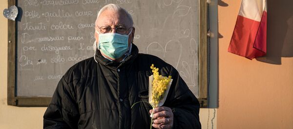 Жизнь в красной зоне: человек в защитной маске держит букет цветов на улице на 16-й день карантина в Сан-Фьорано, одном из 11 небольших городов на севере Италии, который был заблокирован с февраля (7 марта 2020). Италия - Sputnik Армения
