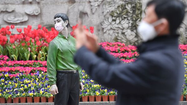 Мужчина фотографирует статую в защитной маске, Пекин - Sputnik Армения