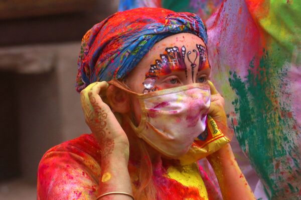 Турист в медицинской маске во время празднования фестиваля Холи в Пушкаре, Индия - Sputnik Армения