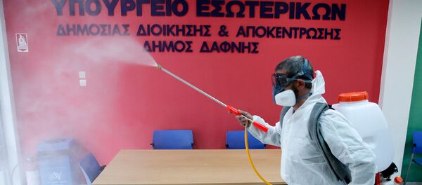 Рабочий в защитном костюме дезинфицирует офис гражданской службы в восточном пригороде Афин Дафни (9 марта 2020). Греция - Sputnik Արմենիա
