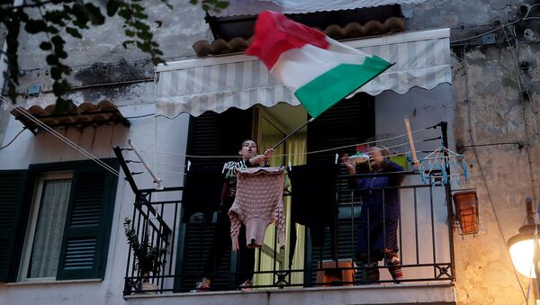 Жительница с флагом Италии из окна во время флешмоба, запущенного по всей Италии, чтобы собрать людей вместе и попытаться справиться с чрезвычайной ситуацией коронавируса (13 марта 2020). Неаполь - Sputnik Армения