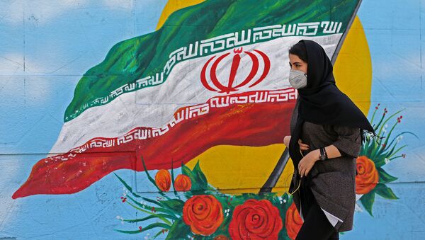 Жительница Ирана в масках проходят мимо граффити с изображением национального флага (4 марта 2020). Тегеран - Sputnik Армения