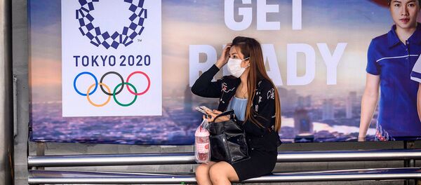 Женщина в защитной маске на автобусной остановке перед рекламой Олимпийских игр Токио-2020 (16 марта 2020). Бангкок - Sputnik Արմենիա