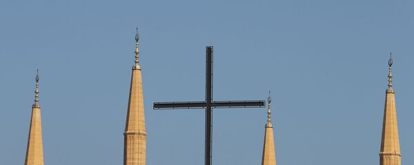 Крест бейрутской Церкви Лазарита на фоне минаретов мечети Мухаммеда аль-Амина в центре ливанской столицы (9 октября 2014). Бейрут - Sputnik Армения
