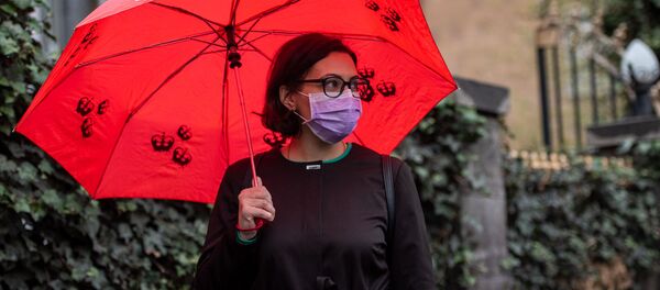 Девушка в защитной маске и зонтом на улице Московян Девушка в защитной маске и зонтом на улице Московян - Sputnik Армения