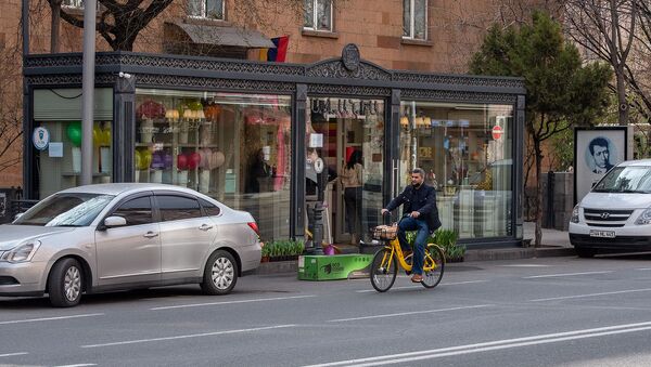 Велосипедист проезжает мимо цветочного магазина на улице Амиряна - Sputnik Армения