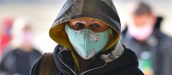 Пассажир в защитной медицинской маске в минском аэропорту в связи с коронавирусом - Sputnik Армения
