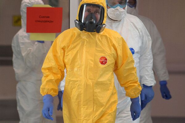 Президент России Владимир Путин (в жёлтом комбинезоне) во время посещения больницы, предназначенной для пациентов с подозрением на коронавирус (24 марта 2020). Поселок Коммунарка - Sputnik Армения