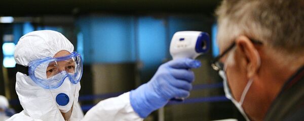 Медицинский работник измеряет температуру пассажиру в аэропорту Внуково Медицинский работник измеряет температуру пассажиру в аэропорту Внуково - Sputnik Արմենիա