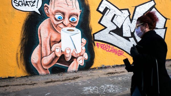 Женщина проходит мимо граффити с изображением Голлума из Властелина колец, держащего в руках рулон туалетной бумаги и говорящего Моя прелесть (21 марта 2020). Берлин - Sputnik Армения