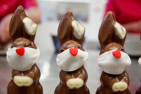 Шоколадные пасхальные кролики в защитных масках в пекарне Baeckerei Bohnenblust в Берне, Швейцария - Sputnik Армения
