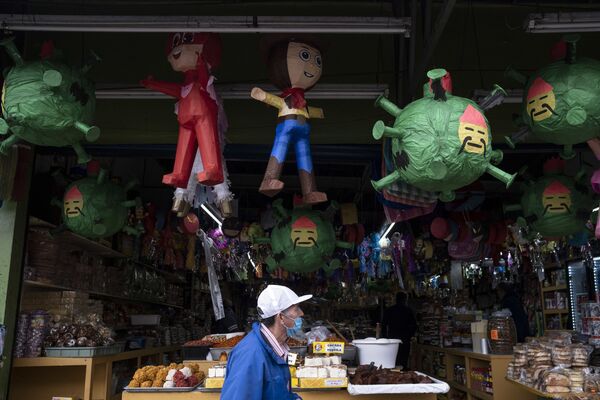 Մեքսիկայում պաշտպանիչ դիմակով տղամարդը անցնում է խաղալիքների խանութի կողքով, որտեղ կորոնավիրուսի բջիջի տեսքով խաղալիքներ կան - Sputnik Արմենիա