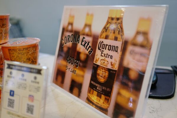 Вывеска с рекламой пива Corona со скидкой на стойке регистрации отеля Osaka Corona в Японии  - Sputnik Армения