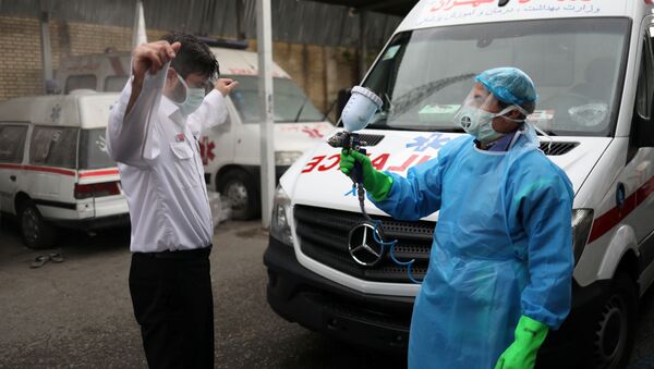 Член экстренного медицинского персонала проходит дезинфекцию после перевода пациента с коронавирусной болезнью (30 марта 2020). Тегеран - Sputnik Армения