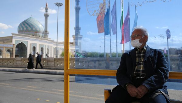 Мужчина в защитной маске на автобусной остановке в городе Кум (24 марта 2020). Иран - Sputnik Արմենիա