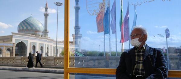 Мужчина в защитной маске на автобусной остановке в городе Кум (24 марта 2020). Иран - Sputnik Армения