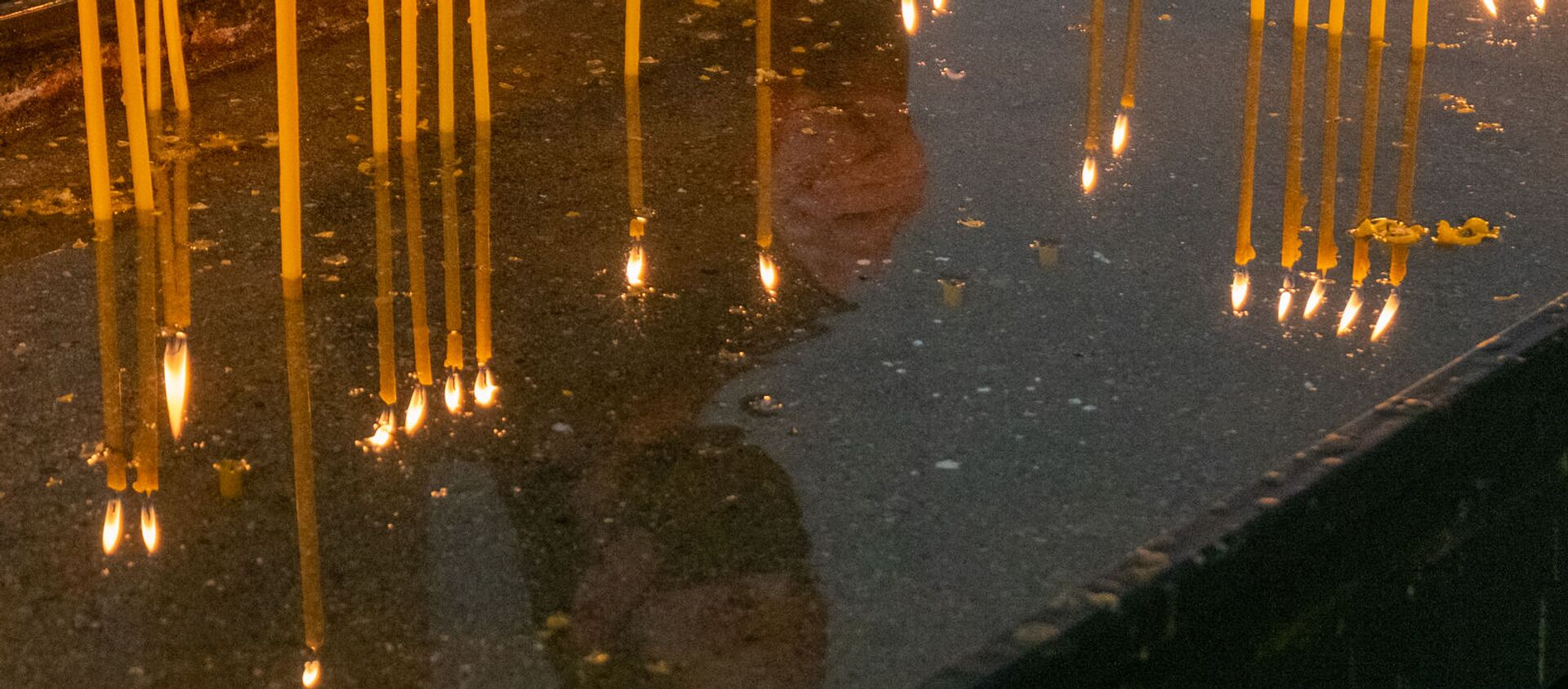 Верующий зажигает свечу в Вербное воскресенье в церкви Святого Креста - Sputnik Արմենիա, 1920, 12.04.2020