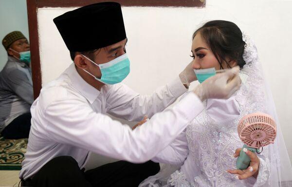 Жених и невеста в масках в Джакарте - Sputnik Армения