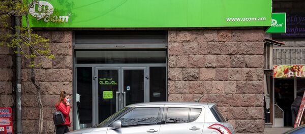 Девушка с телефоном проходит мимо офиса компании Ucom на проспекте Маштоца (10 апреля 2020). Еревaн - Sputnik Армения