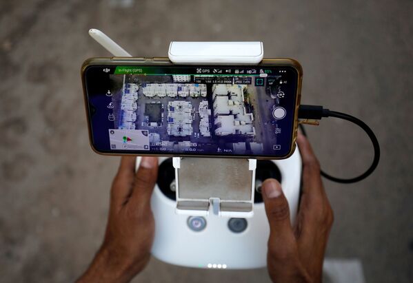 Пульт управления беспилотником для наблюдения за передвижением людей в связи с коронавирусом в жилом районе в Ахмедабаде, Индия - Sputnik Армения