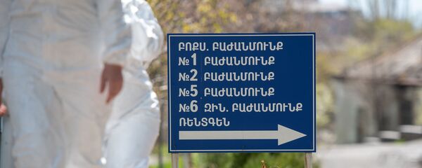Сотрудники инфекционной больницы Норк проходят мимо указателя Сотрудники инфекционной больницы Норк проходят мимо указателя - Sputnik Արմենիա