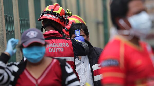 Пожарный измеряет температуру покупателя перед входом на рынок Сан-Роке в качестве меры предотвращения распространения нового коронавируса (9 апреля 2020). Кито, Эквадор - Sputnik Армения