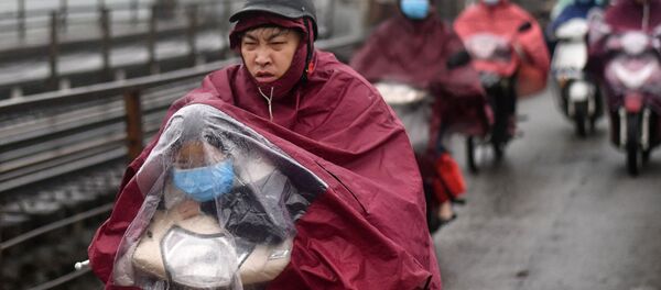 Ребенок в защитной маске и под дождевиком на скутере в Ханое, Вьетнам - Sputnik Армения