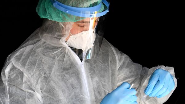 Сотрудник клиники проверяет биоматериал пациентов на наличие коронавируса - Sputnik Армения