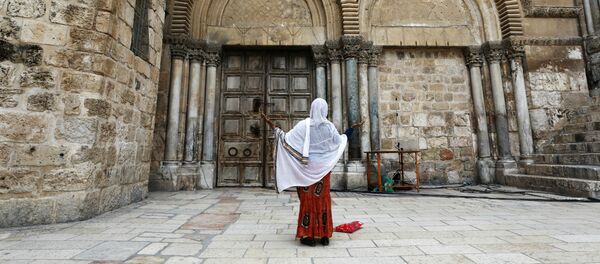 Женщина молится рядом с закрытыми дверями Храма Гроба Господня во время празднования Страстной пятницы на фоне вспышки коронавируса (17 апреля 2020). Иерусалим Женщина молится рядом с закрытыми дверями Храма Гроба Господня во время празднования Страстной пятницы на фоне вспышки коронавируса (17 апреля 2020). Иерусалим - Sputnik Армения