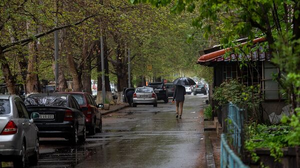 Молодой человек с зонтом на улице Арами - Sputnik Արմենիա