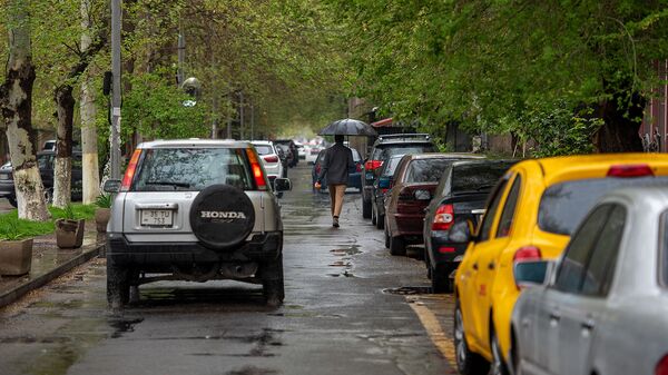 Молодой человек с зонтом на улице Арами - Sputnik Армения