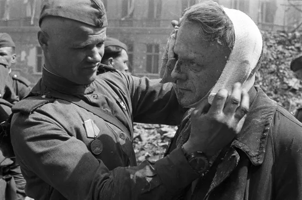 Советский солдат делает перевязку раненому берлинцу, 1945 год Советский солдат делает перевязку раненому берлинцу, 1945 год - Sputnik Армения