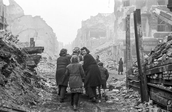 Жители Берлина возвращаются домой по заваленной обломками домов улице, 1945 год - Sputnik Армения