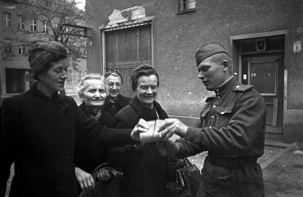 Советский солдат раздает хлеб жительницам Берлина, 7 мая 1945 года - Sputnik Армения