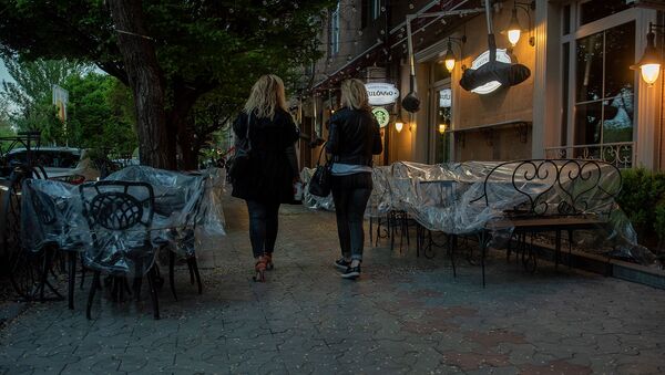 Женщины проходят мимо закрытого кафе на улице Таманяна в Ереване - Sputnik Արմենիա