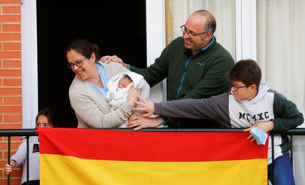 Семья из Ронды показывает соседям своего новорожденного ребенка в период пандемии коронавируса в Испании - Sputnik Армения