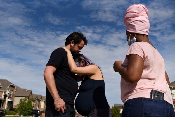 Беременная женщина испытывает схватки во время прогулки со своим партнером возле дома акушерки во время эпидемии коронавируса Форт-Уэрте, штат Техас, США - Sputnik Армения