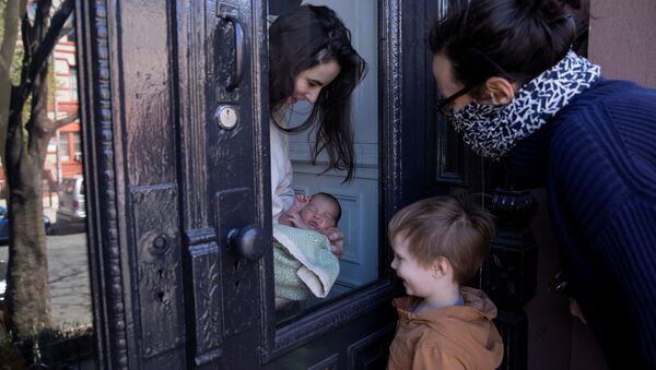 Девушка показывает своего новорожденного ребенка родственникам через стекло в Бруклинском районе Нью-Йорка, США - Sputnik Армения